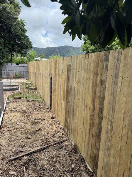 A new timber paling fence along a cleared boundary